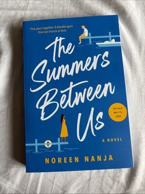The Summers Between Us by Noreen Nanja — Blue Paperback Novel